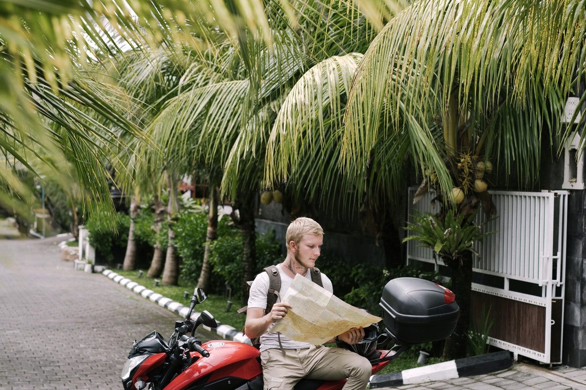Traveler studying map of city on motorcycle